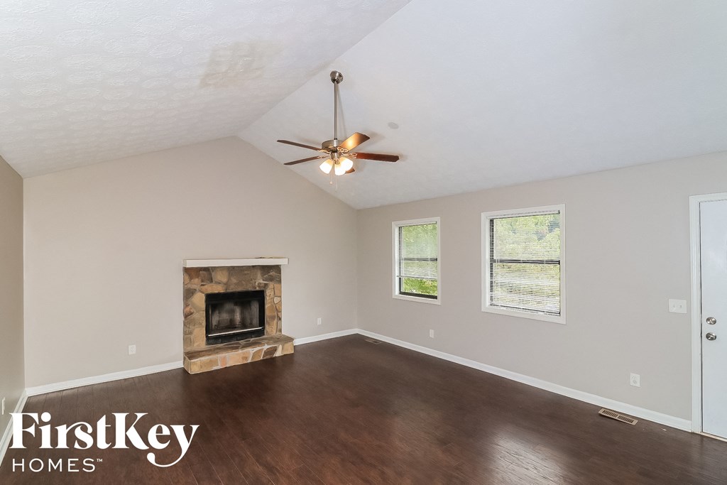 a living room with a fireplace and a ceiling fan