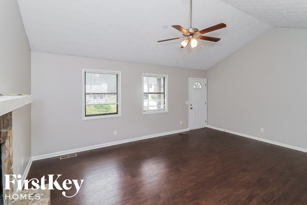 a living room with wood floors and a ceiling fan