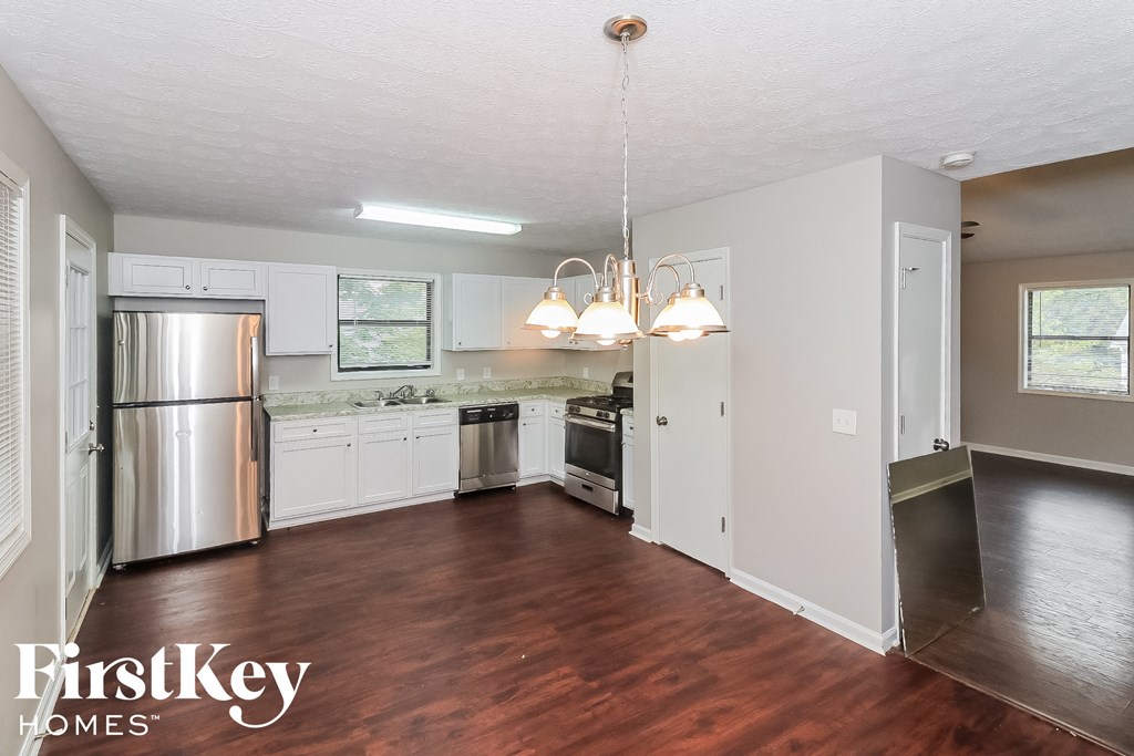 a kitchen with white cabinets and a stainless steel refrigerator