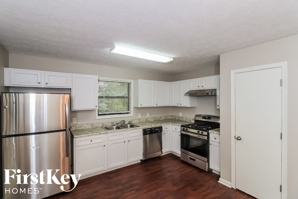 a small kitchen with white cabinets and stainless steel appliances