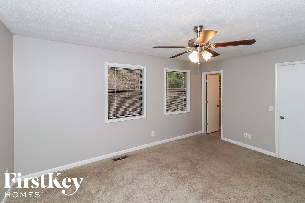 the living room of an empty house with a ceiling fan
