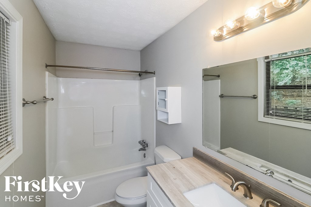 a white bathroom with a white toilet and a white sink
