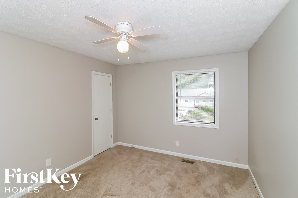 a bedroom with a ceiling fan and a window