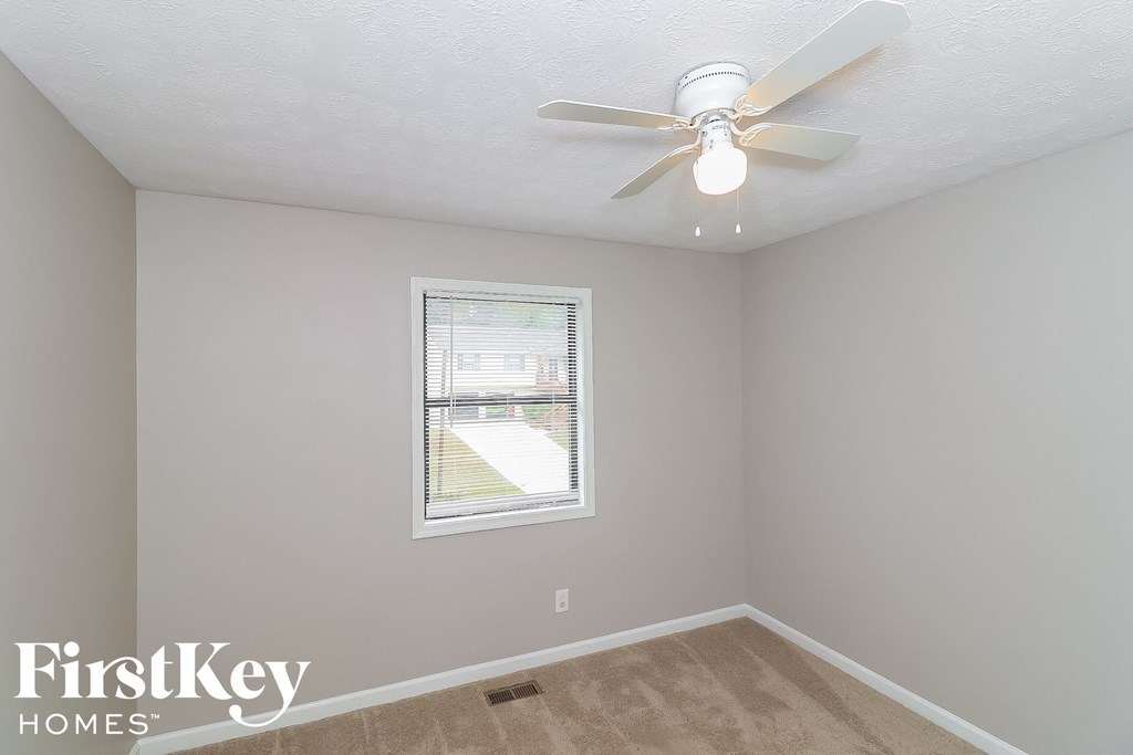 a bedroom with a ceiling fan and a window