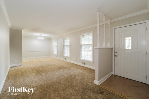 A room with a carpeted floor and a door on the right side.