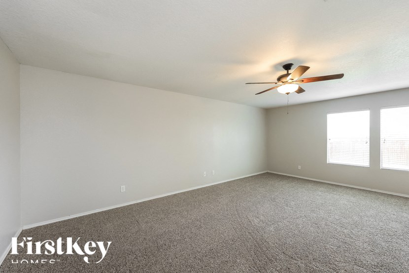 the living room of an empty house with a ceiling fan