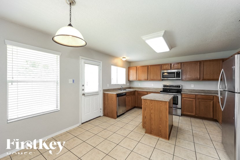 a kitchen with wooden cabinets and a large window