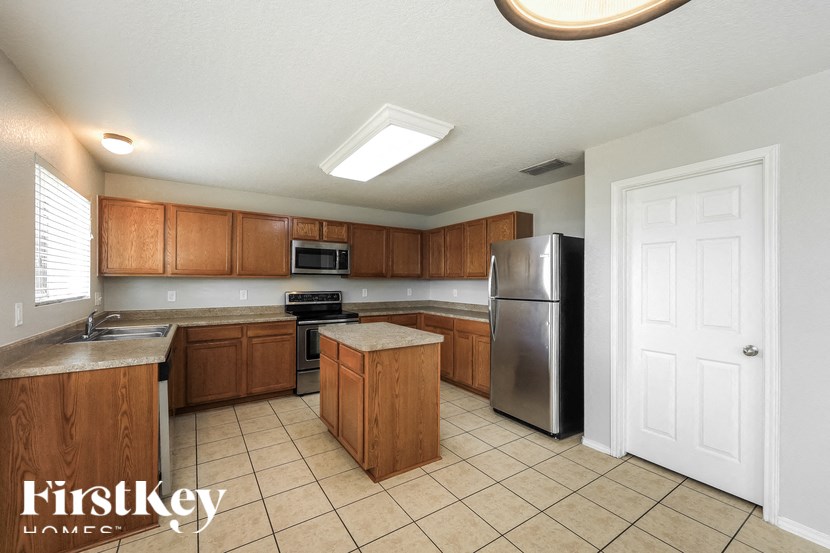 a kitchen with wooden cabinets and a stainless steel refrigerator