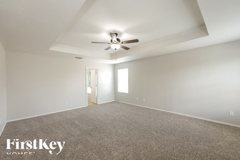 a living room with carpet and a ceiling fan