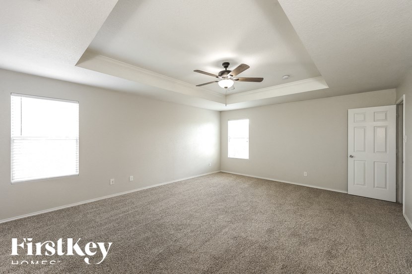 the living room of an empty house with a ceiling fan