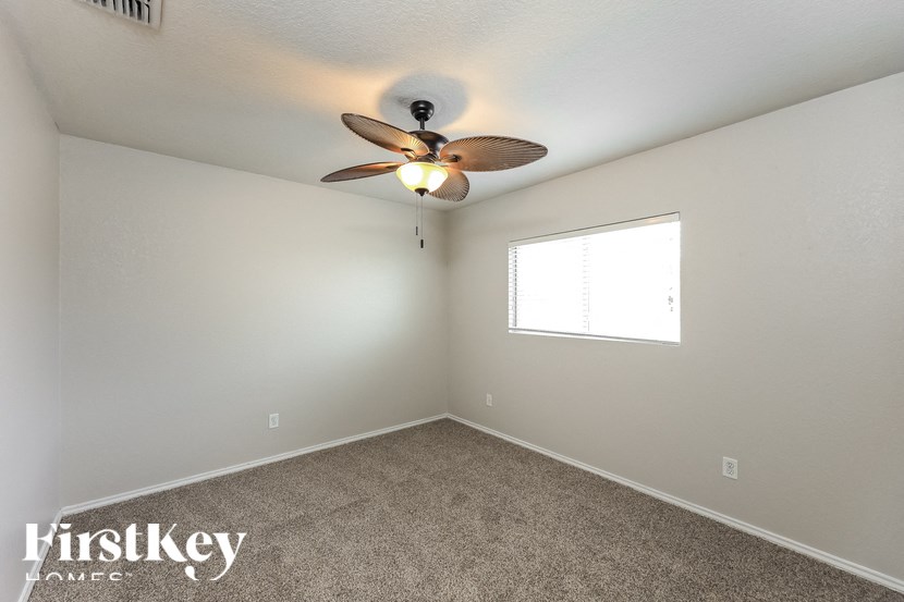 a bedroom with a ceiling fan and a window