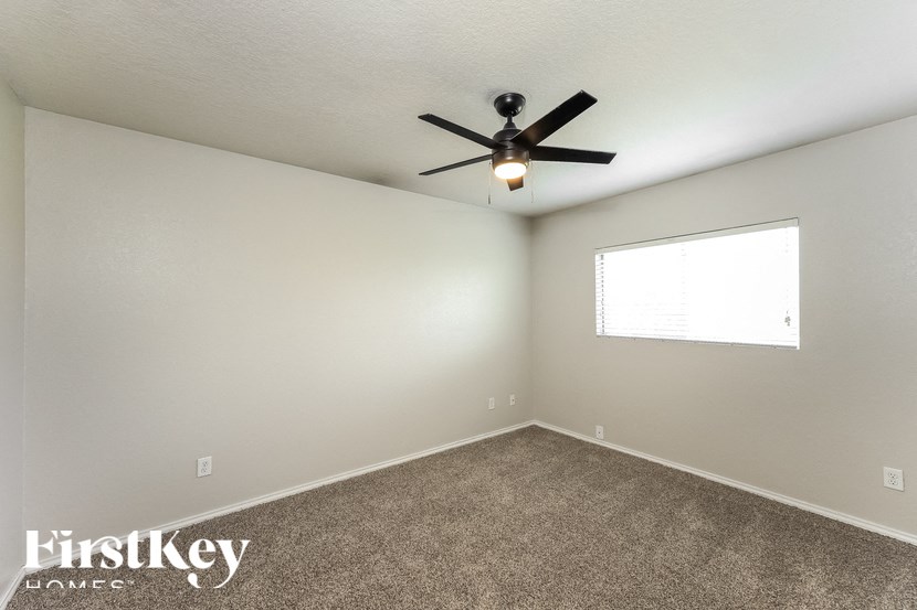 a living room with a ceiling fan and a window