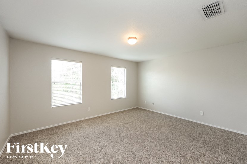 the spacious living room with carpeting and two windows
