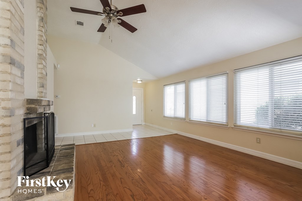 the living room with wood floors and a fireplace