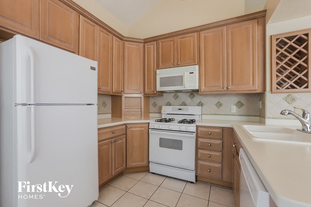 a kitchen with white appliances and wooden cabinets