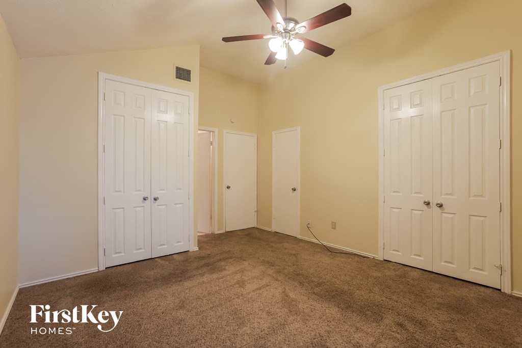 a bedroom with two closets and a ceiling fan