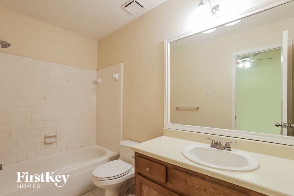a bathroom with a sink toilet and mirror and a tub