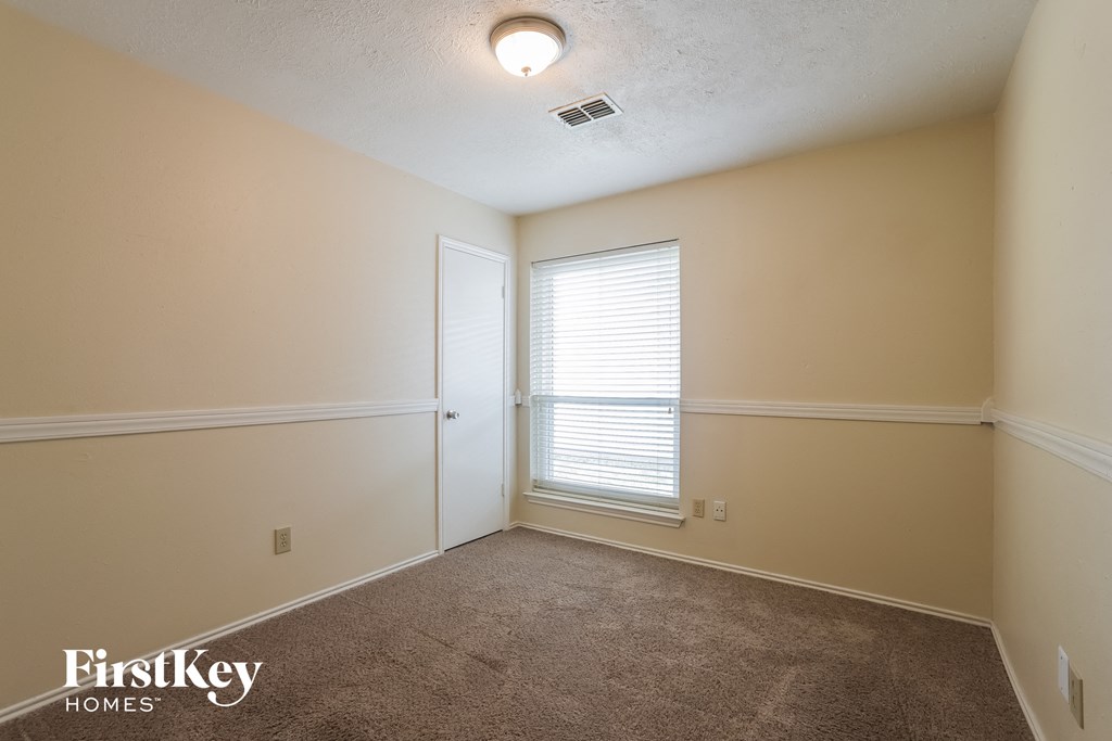 a bedroom with a carpeted floor and a window