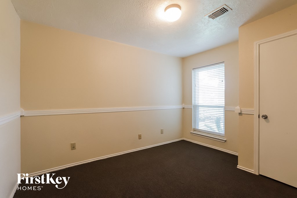 the interior of an empty room with a door and a window