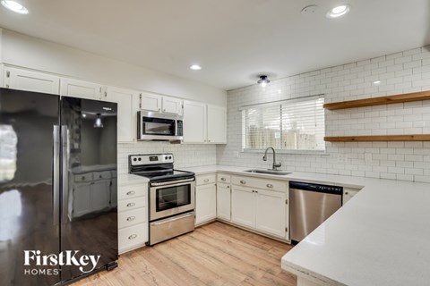 A kitchen with white cabinets and a stainless steel dishwasher.