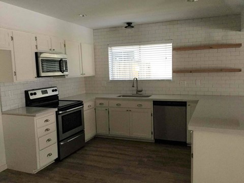 A kitchen with white cabinets and a black stove top oven.