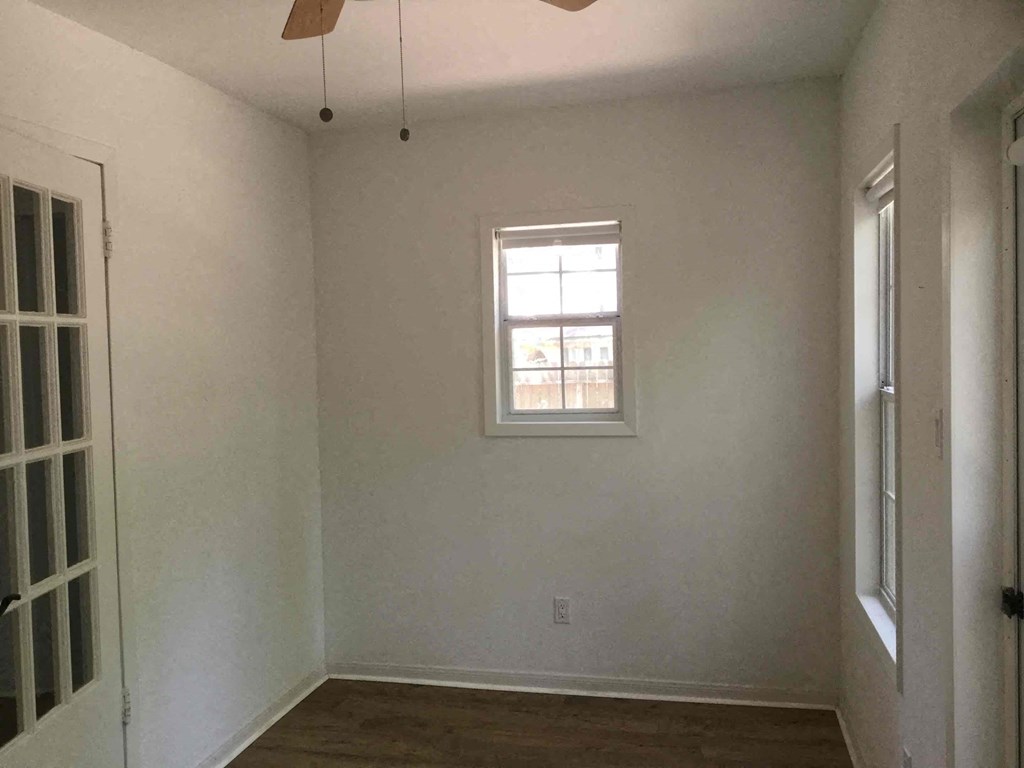 A room with a window and a ceiling fan.