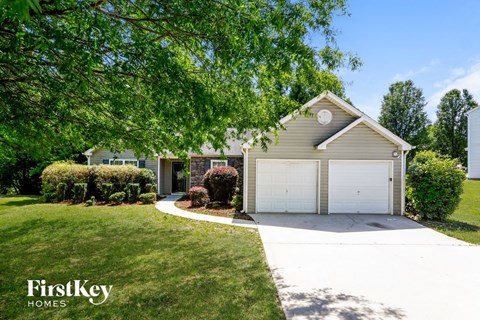 a home with a white driveway and a white garage door
