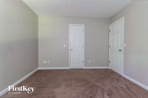 a bedroom with a carpeted floor and two doors