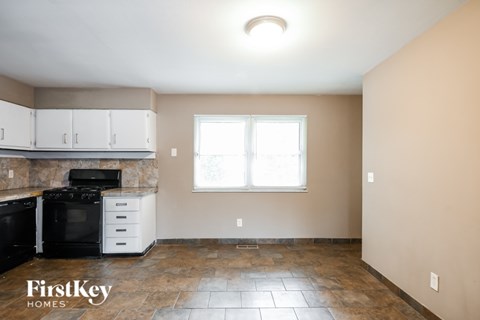 A kitchen with a black stove top oven and white cabinets.