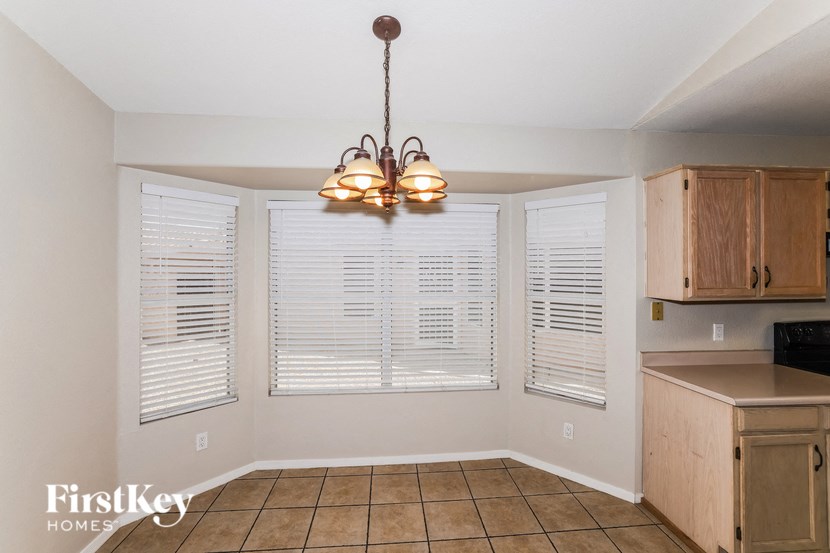 A kitchen with a tile floor and a chandelier hanging from the ceiling.