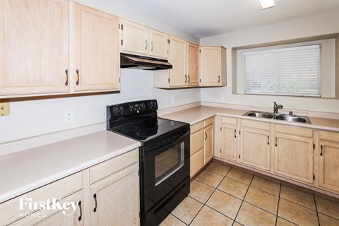 A kitchen with wooden cabinets and a black stove top oven.