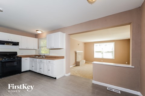 a kitchen with white cabinets and a black stove and a white counter top