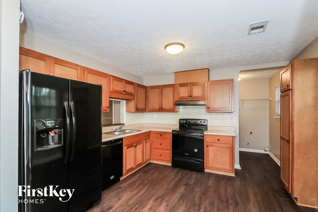 a kitchen with black appliances and wooden cabinets