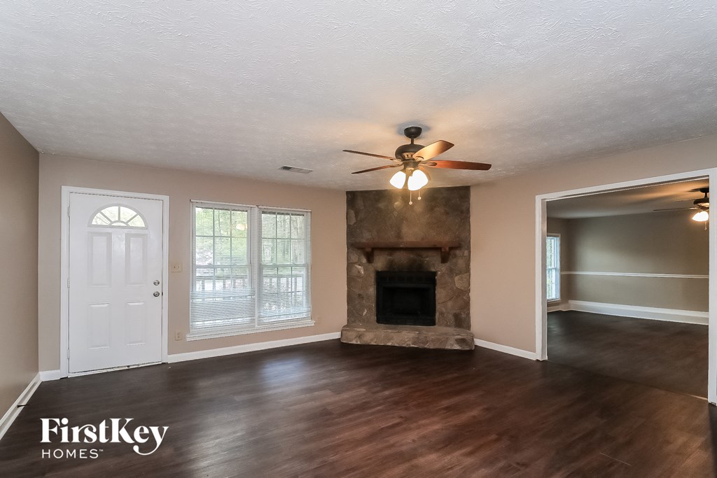 a living room with a fireplace and a ceiling fan