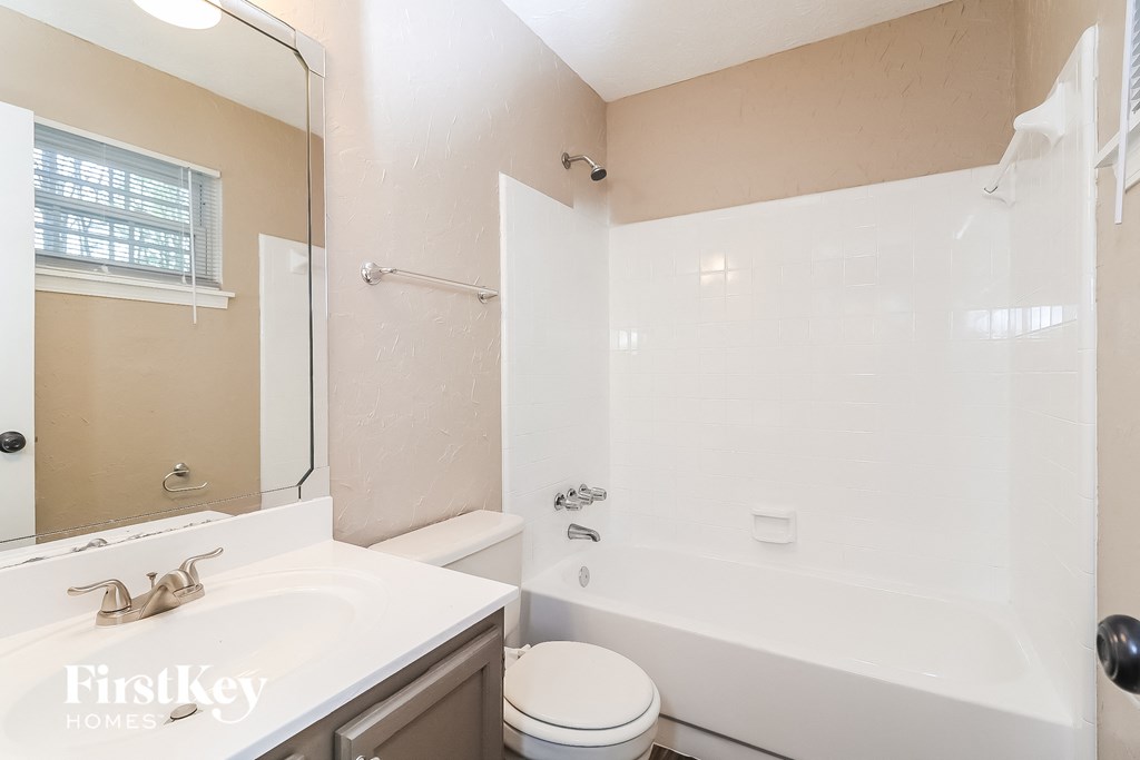 a bathroom with a tub and a sink and a toilet