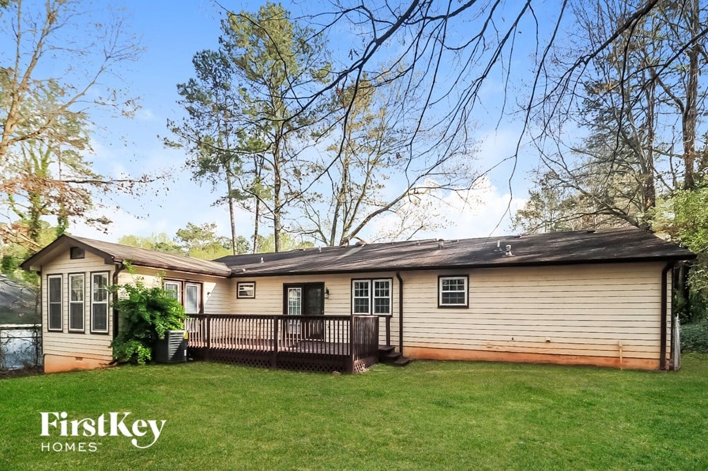 a small house with a fenced in yard and a pond