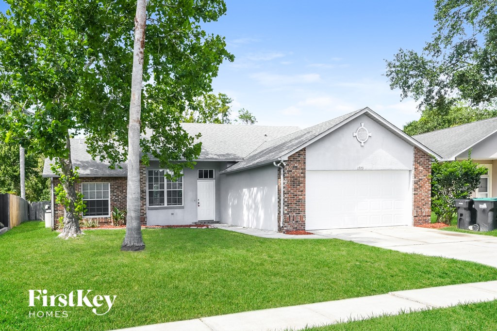 a white house with a lawn and a white garage door