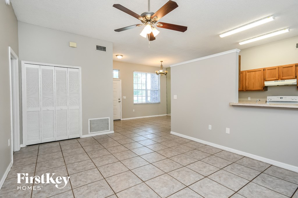 an empty kitchen and living room with a ceiling fan