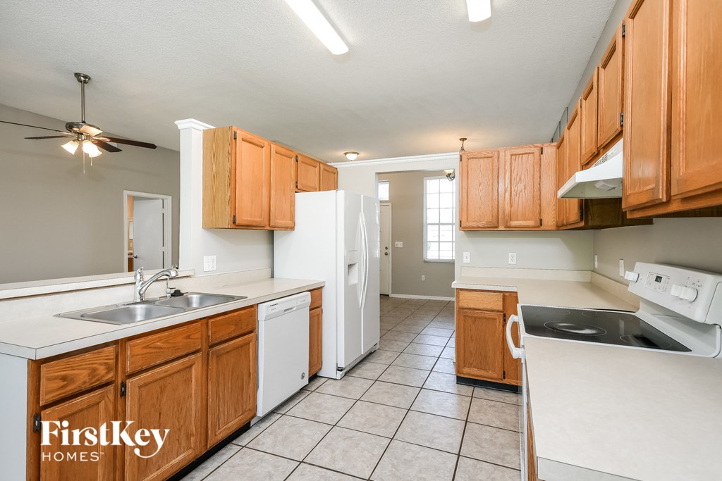 a kitchen with white appliances and wooden cabinets