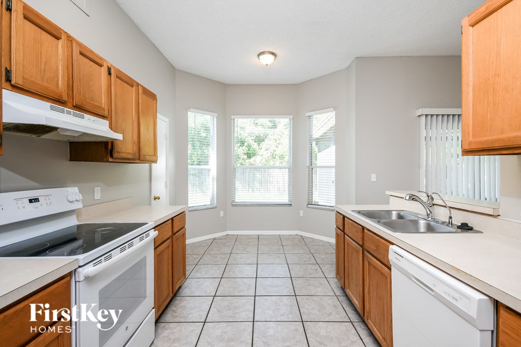 a kitchen with white appliances and wooden cabinets