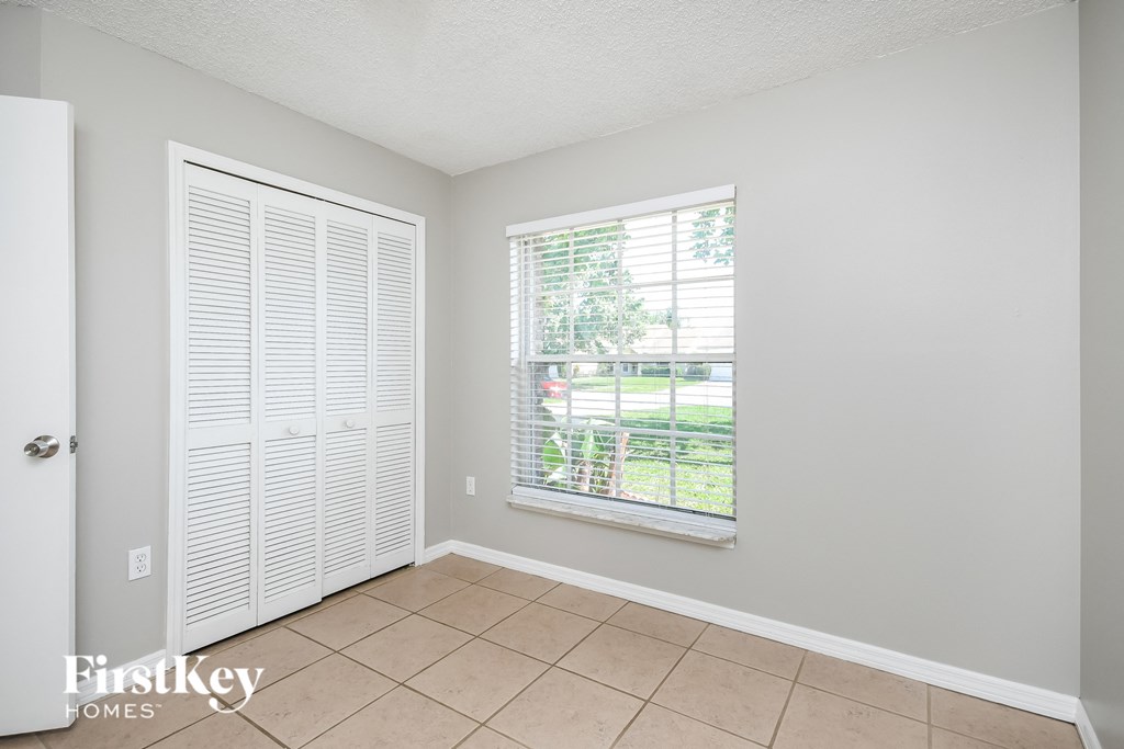 a living room with a large window and a tiled floor