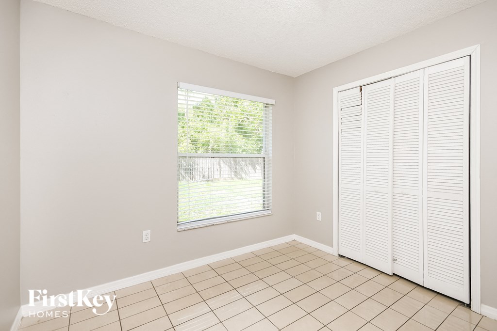 a living room with a large window and a tiled floor