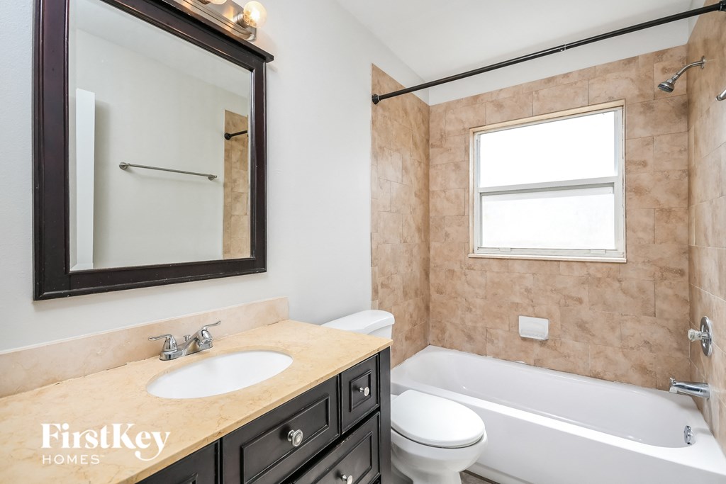 a bathroom with a sink toilet and tub and a mirror