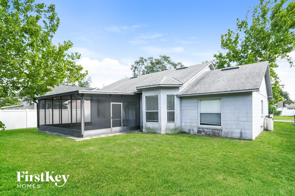 a white house with a grass yard and a white fence