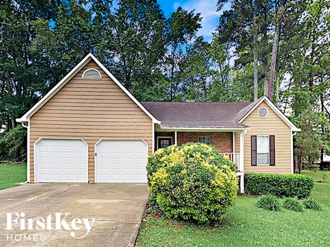 a home with two garages and a lawn and trees