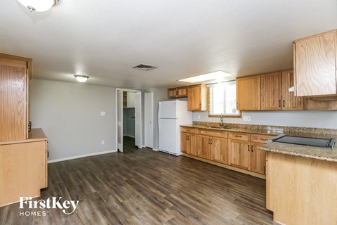 A kitchen with wooden cabinets and a white refrigerator.