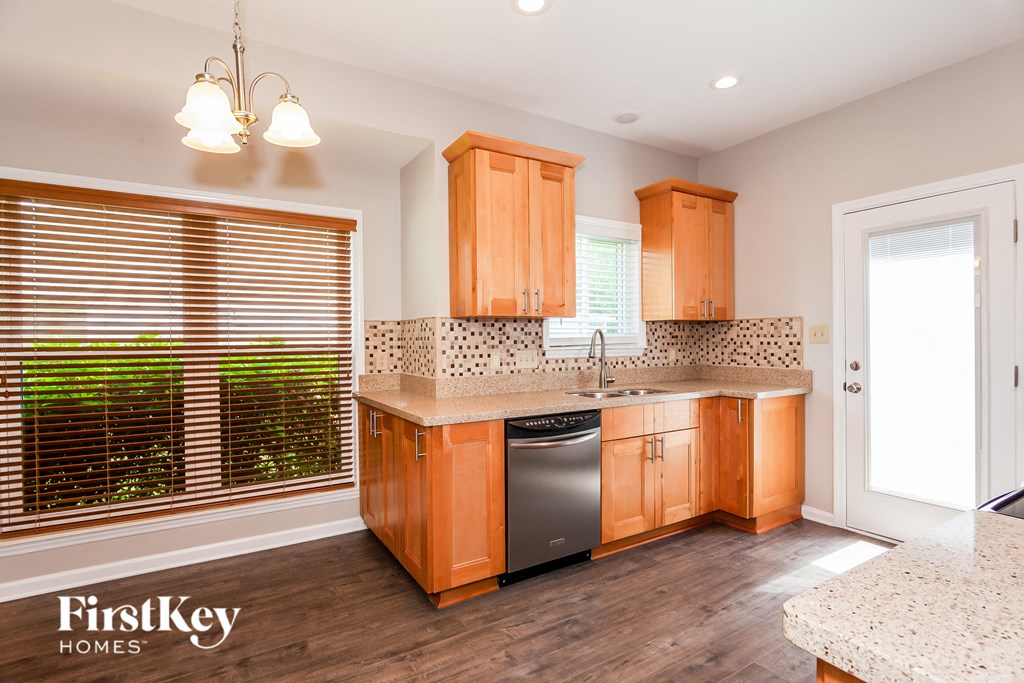 a kitchen with wooden cabinets and a dishwasher and a window
