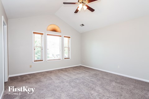 a living room with carpet and a ceiling fan