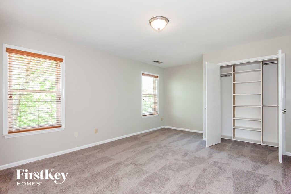 the master bedroom is spacious and clean with a large closet and window