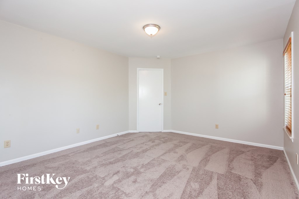 a empty living room with carpet and white walls